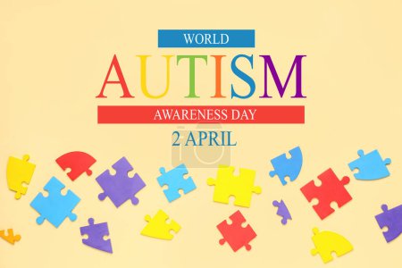 Photo for Jigsaw puzzle pieces and text WORLD AUTISM AWARENESS DAY on beige background - Royalty Free Image