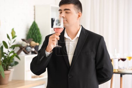 Téléchargez les photos : Jeune sommelier avec verre de vin rose dans la cuisine - en image libre de droit