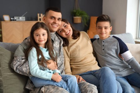 Soldat avec sa femme et ses petits enfants assis sur le canapé à la maison