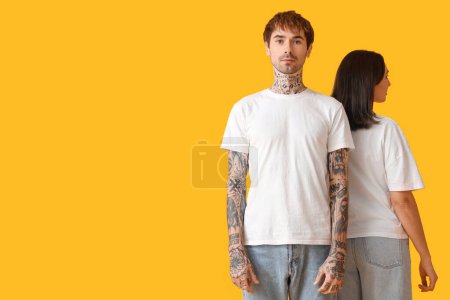 Photo for Young couple in white t-shirts on yellow background - Royalty Free Image