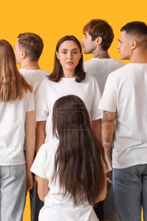 Photo for Group of young people in white t-shirts on yellow background - Royalty Free Image