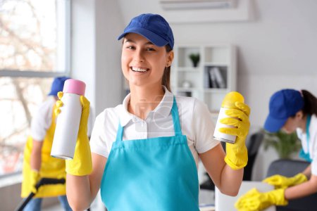 Female worker of cleaning service with air fresheners in office