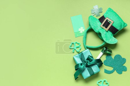 Leprechaun hat with gift box and clovers on green background. St. Patrick's Day celebration
