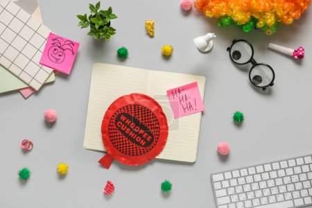 Computer keyboard with whoopee cushion, funny glasses and sticky notes on white background. April Fools Day prank