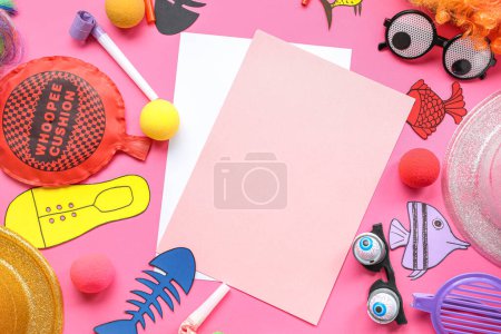 Blank cards with paper fishes, whoopee cushion and party decor on pink background. April Fools Day celebration