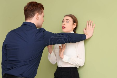 Photo for Business man molesting his female colleague on green background. Harassment concept - Royalty Free Image