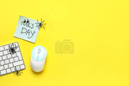 Foto de Arañas de juguete en el teclado de la computadora sobre fondo amarillo. Broma del Día de los Inocentes - Imagen libre de derechos