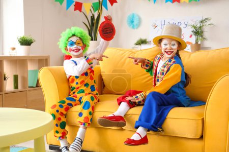 Lustige kleine Kinder in Clownskostümen zu Hause. Feier zum Aprilscherz