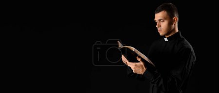 Junger Priester liest Bibel auf dunklem Hintergrund mit Platz für Text