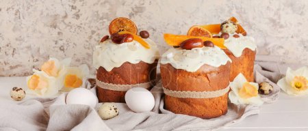 Photo for Easter cakes, narcissus flowers and eggs on table near grunge wall - Royalty Free Image