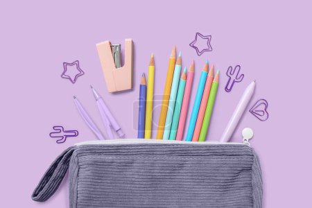 Foto de Estuche con papelería escolar y lápices sobre fondo lila - Imagen libre de derechos