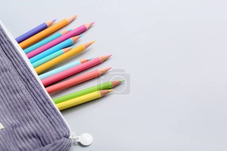 Foto de Estuche con muchos lápices de colores sobre fondo gris - Imagen libre de derechos