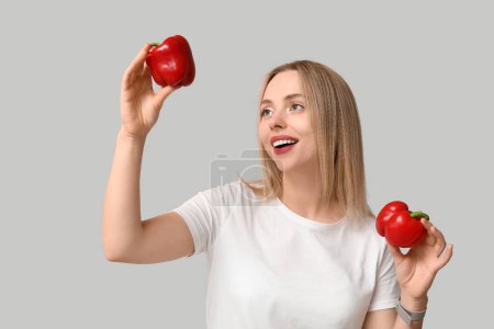Photo for Young woman with bell peppers on light background - Royalty Free Image