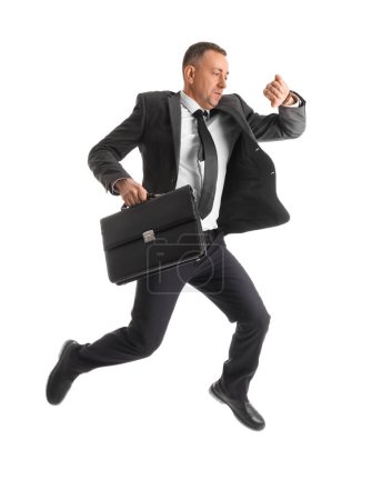 Foto de Empresario apresurado con maletín comprobando el tiempo mientras salta sobre fondo blanco - Imagen libre de derechos
