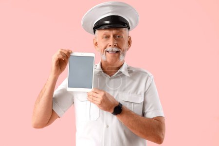 Photo for Mature sailor with tablet computer on pink background - Royalty Free Image