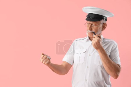 Photo for Mature sailor with clock smoking pipe on pink background - Royalty Free Image
