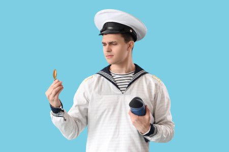 Young sailor with compass and world map on blue background