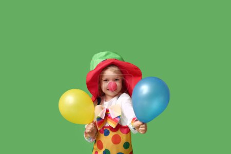 Foto de Linda chica en traje de payaso con globos sobre fondo verde - Imagen libre de derechos