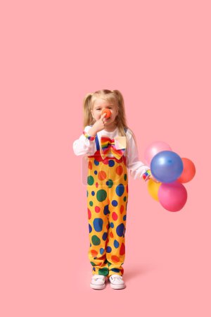 Foto de Linda niña en traje de payaso con globos sobre fondo rosa - Imagen libre de derechos