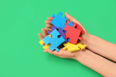 Photo for Female hands holding color puzzle on green background. Concept of autistic disorder - Royalty Free Image