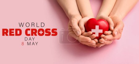 Manos de mujer y niño con corazón sobre fondo rosa. Banner para el Día Mundial de la Cruz Roja
