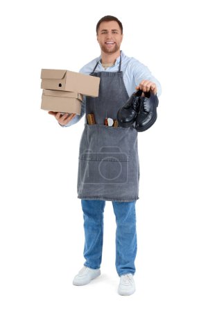 Male shoemaker with shoes and boxes on white background