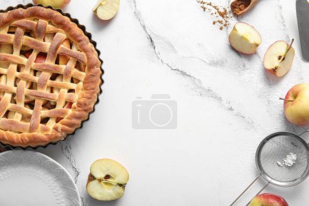 Marco hecho de sabroso pastel de manzana casero con colador y frutas sobre fondo grunge blanco