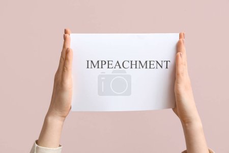 Woman holding IMPEACHMENT picket poster on pink background