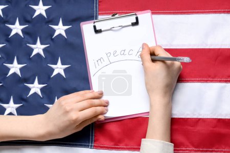 Woman writing word IMPEACH on clipboard against USA FLAG