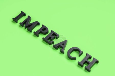 Black letters spelling word IMPEACHMENT on green background