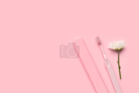 Téléchargez les photos : Brosse à dents, étui et fleur de camomille sur fond rose - en image libre de droit