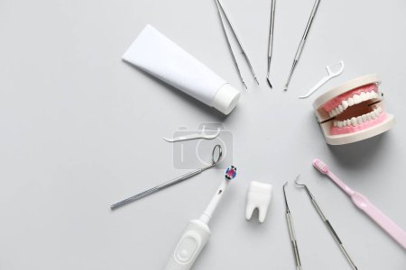Téléchargez les photos : Cadre fabriqué à partir d'outils dentaires, de fournitures d'hygiène buccale et de modèles en plastique sur fond blanc. Journée mondiale des dentistes - en image libre de droit