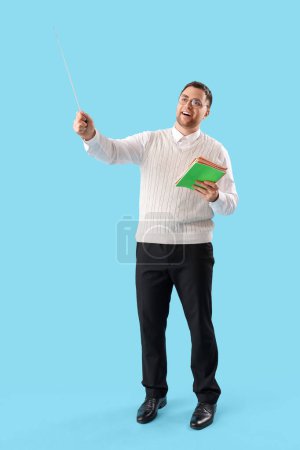 Photo for Male teacher with pointer and copybooks on blue background - Royalty Free Image