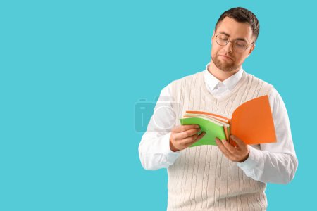 Photo for Male teacher with copybooks on blue background - Royalty Free Image