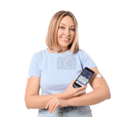 Femme diabétique avec capteur de glucose utilisant un téléphone portable pour mesurer le taux de sucre dans le sang sur fond blanc