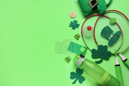Photo for Water bottle, badminton rackets and decorations for St. Patrick's Day celebration on green background - Royalty Free Image