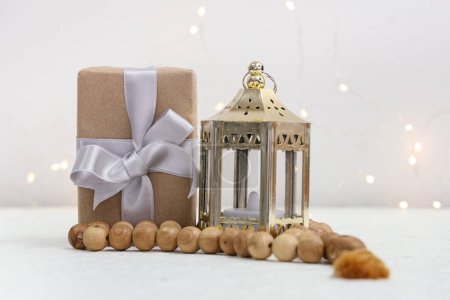 Gift box with Muslim lamp and prayer beads for Ramadan on white table