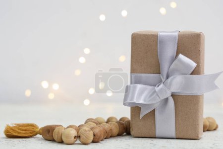 Caja de regalo con cuentas de oración para Ramadán sobre mesa blanca