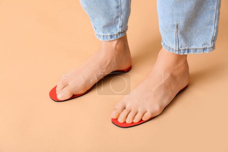 Photo for Female feet on orthopedic insoles on beige background, closeup - Royalty Free Image