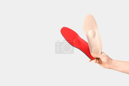 Photo for Female hands holding orthopedic insoles isolated on white background - Royalty Free Image