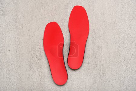 Photo for Red orthopedic insoles on grey grunge background - Royalty Free Image