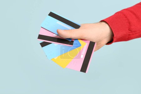 Male hand with credit cards on blue background