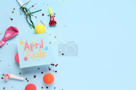 Festive postcard for April Fools Day with party whistles, clown noses and sequins on blue background