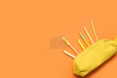 Foto de Caja de lápiz con papelería sobre fondo naranja. Vista superior - Imagen libre de derechos