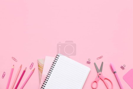 Foto de Cuaderno, lápices y tijeras sobre fondo rosa. Vista superior - Imagen libre de derechos