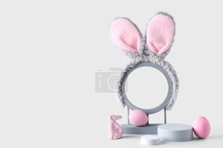 Photo for Decorative podiums with bunny ears, Easter eggs and toy rabbit on grey background - Royalty Free Image