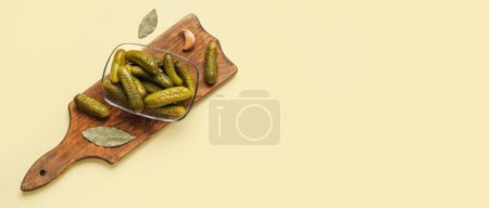Téléchargez les photos : Bol de savoureux concombres marinés et épices sur fond beige avec espace pour le texte, vue du dessus - en image libre de droit