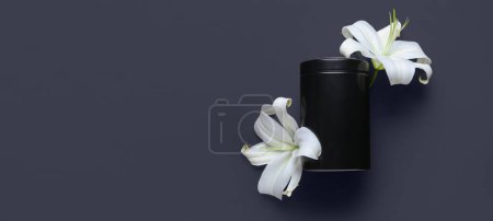 Mortuary urn and white lily flowers on black background with space for text. Funeral concept