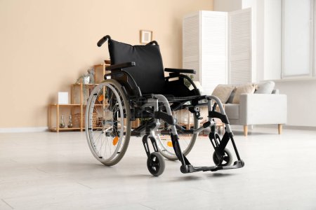 Foto de Moderna silla de ruedas vacía en salón cerca de la pared beige - Imagen libre de derechos
