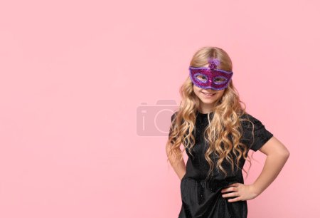 Photo for Happy little girl wearing carnival mask on pink background - Royalty Free Image